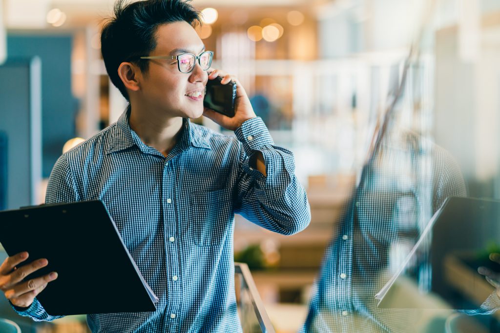 Sempris smart confidence asian startup entrepreneur business owner businessman smile hand use smartphone woking in office background