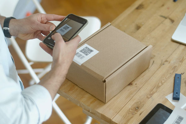 Person scanning a QR code on a box