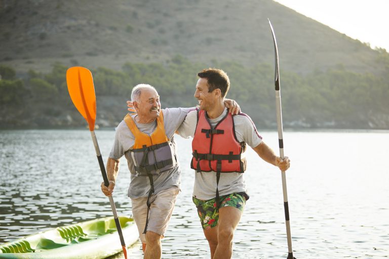 Two men walking with paddles